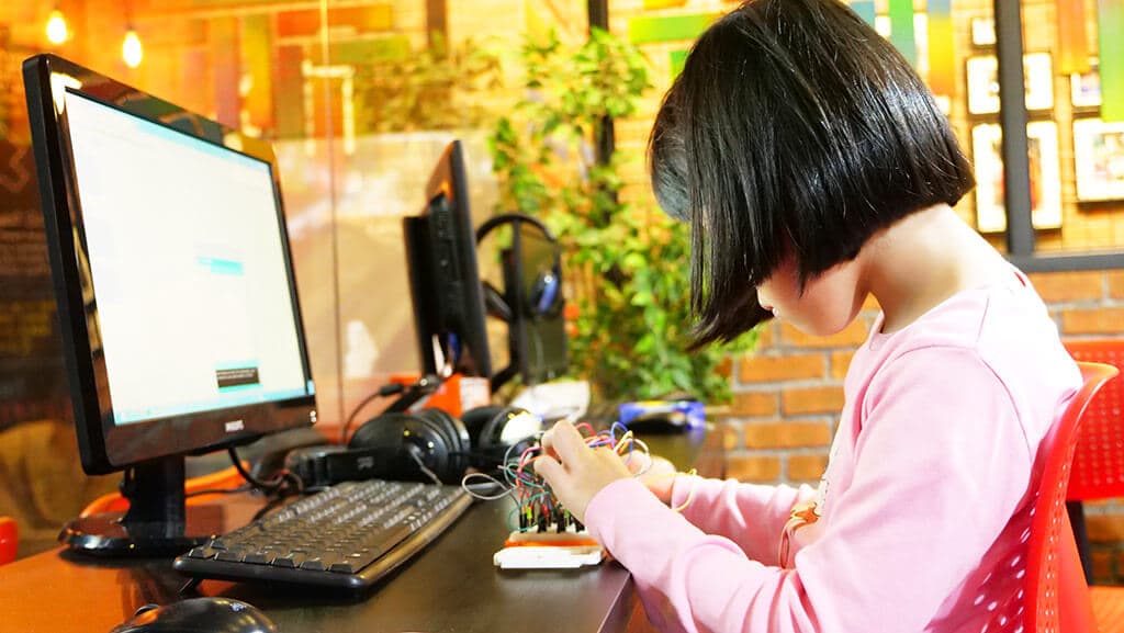Kidocode student wiring an Arduino circuit, applied math live